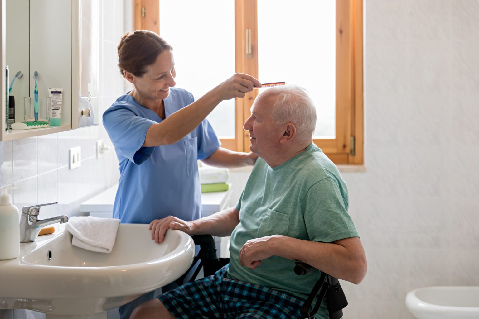 Home Caregiver with senior man in bathroom