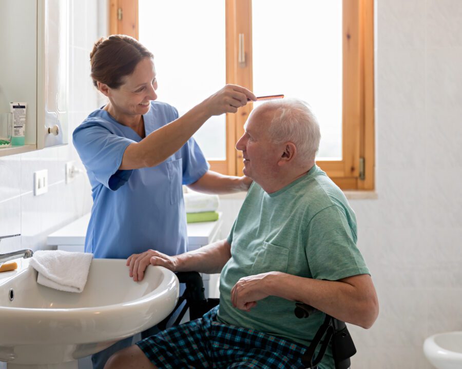 Home Caregiver with senior man in bathroom