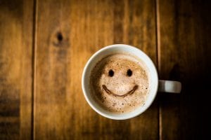 A cup of coffee with a smiley face on it