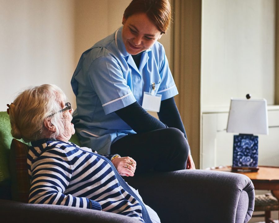 Nurse visiting senior female patient at home