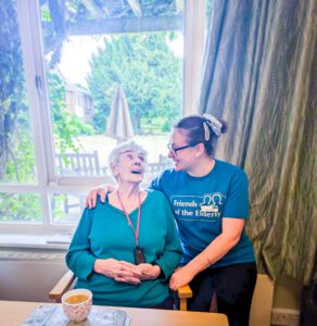 A resident laughing with a member of staff. 