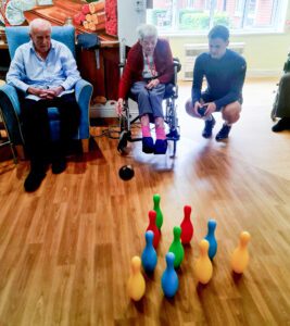 Woking Football Club member with a resident during an exercise session.