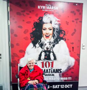 A resident at the theatre with the promotional poster in the background.