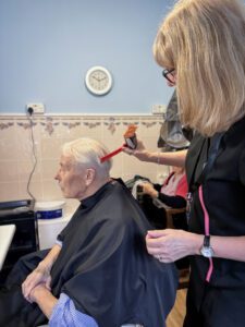 Hairdresser Nicky cutting a resident's hair. 