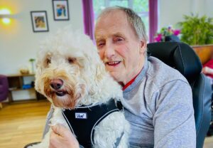 2025 January Highlights: Bernard Sunley care home resident cuddling Jazz the dog.