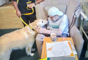 2025 February Highlights: Bailey the dog with a resident. 