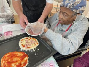 A resident making a pizza. 