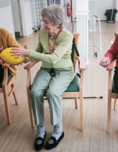 A resident being passed a ball during the exercise session.
