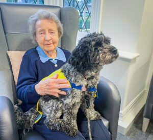 Respite to resident, Margaret, with Winnie the dog on her lap. 