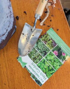 A trowel and packet of seeds. 