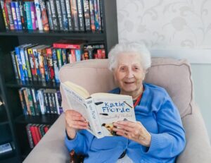 A resident from our Essex care home reading a book on National Book Day.