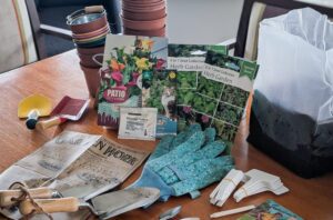 2025 March highlights: A photo of gardening supplies used at our Malvern care home, including trowels, gloves, pots and seeds.