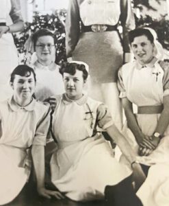 An old black and white photo of Jill when she was a nurse, sat with other nurses.