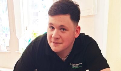 Keelan, who volunteers at Kidderminster Day Care, smiling at the camera.