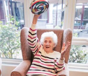 Essex care home resident dancing with a tambourine.