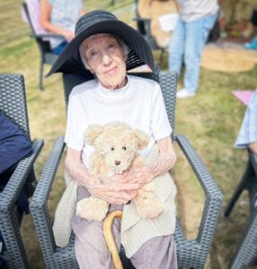 Jill now, sat outside holding a teddy bear.