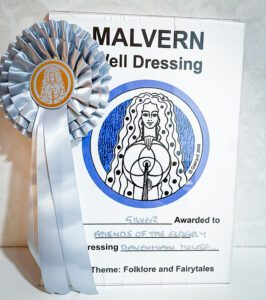 A close up of the silver winning rosette and certificate.